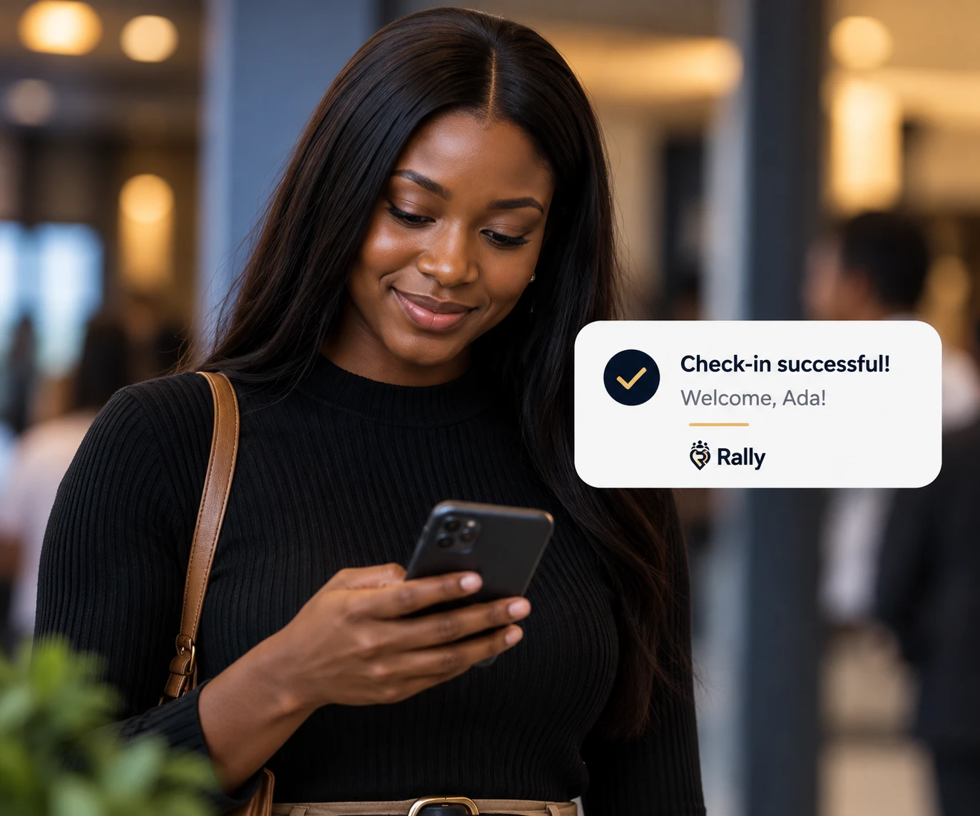 A member smiles at her phone as a Rally notification confirms her check-in